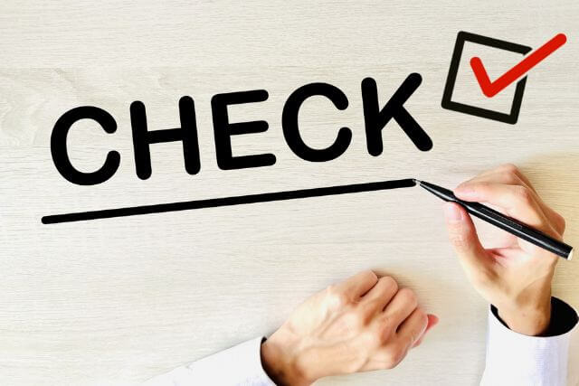 A hand ticking a checkbox on a checklist
